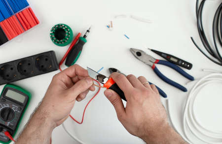 electrician works with a tool. tools on white backgroundの写真素材