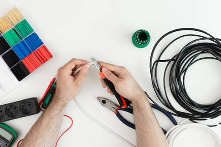 electrician works with a tool. tools on white backgroundの写真素材