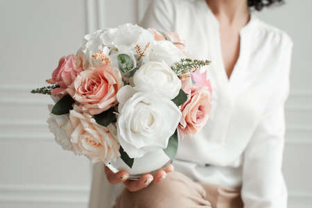 woman holding a bouquet of decorative flowers. artificial flowersの写真素材
