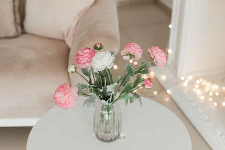 beautiful bouquet of flowers in a glass vase on a white table. interiorの写真素材
