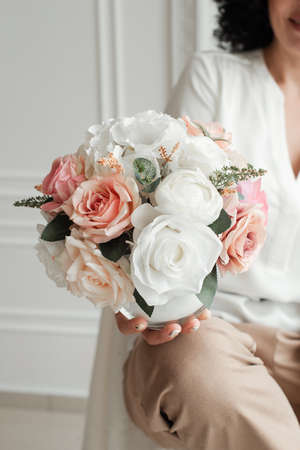 woman holding a bouquet of decorative flowers. artificial flowersの写真素材