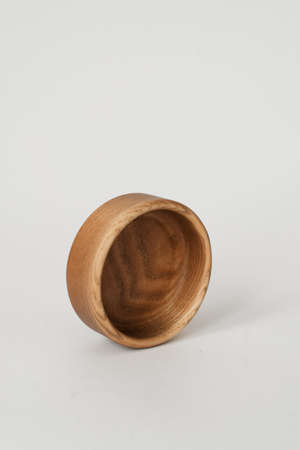 A small round wooden bowl on a white background. A nice little bowl made of wood. Wooden product.の写真素材