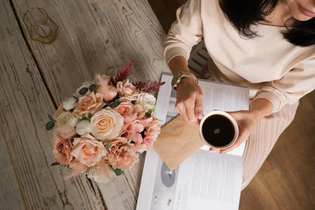 girl with coffee and flowers at a wooden table. textureの写真素材