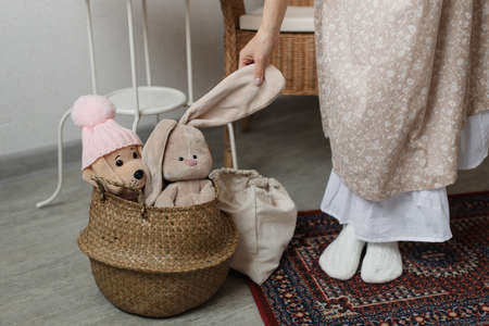 A little girl holding a toy, a girl in a dress playing with her stuffed toy.の写真素材