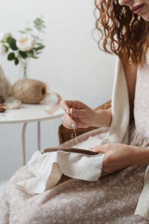 Woman embroidery on a light linen fabric. The process of hand embroidery.