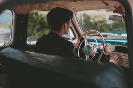 man driving an old car. Retro car salon. Retro photography. Styleの写真素材