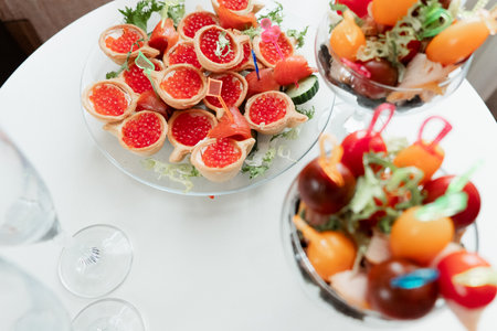 tartlets with red caviar on a white table. Many different food on a white backgroundの写真素材