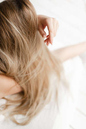 hands and blonde hair close up. Long light hair. hairstyleの写真素材