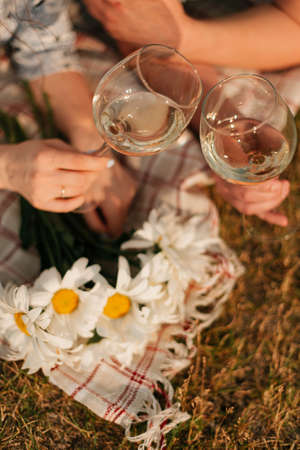 picnic on the grass and 2 glasses of champagne in hand. Summer restの写真素材