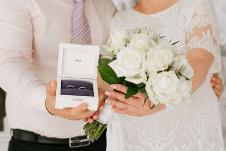 the bride and groom are holding a wedding bouquet and wedding rings. Wedding detailsの写真素材
