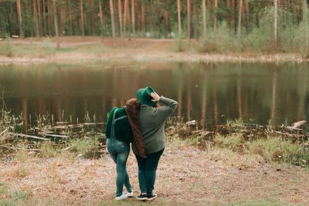 two girlfriends stand by the lake, spring landscape, green color.の写真素材