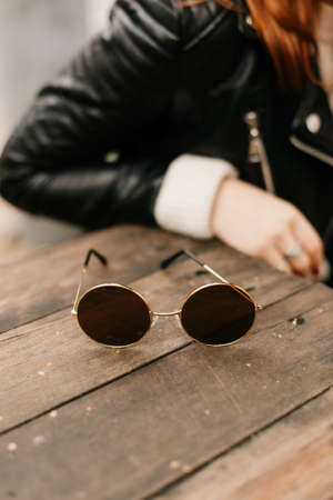 girl in black leather jacket and round shaped sunglasses, stylish peopleの写真素材