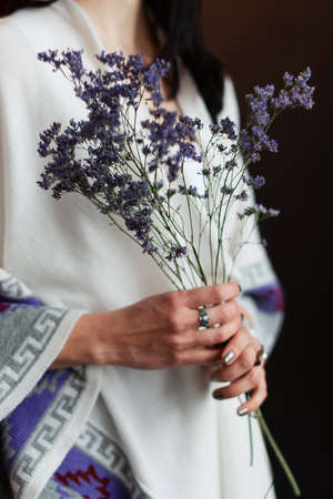 girl in a beautiful dress holding a bouquet of wildflowers, spring photo sessionの写真素材