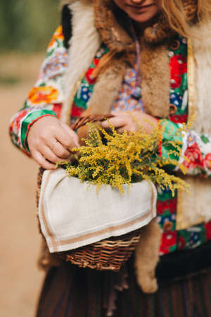 girl in national costume with a basket of flowers close-up National dressの写真素材