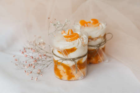 fruit pudding with tangerine in a transparent cup on the tableの写真素材