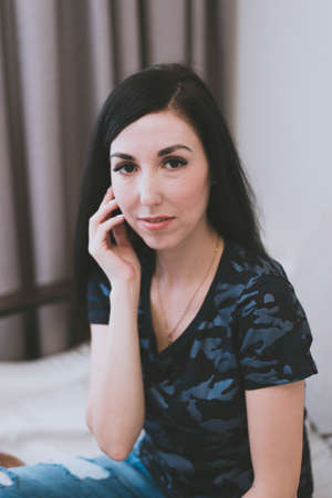 cute brunette girl with black hair in a t-shirt close upの写真素材