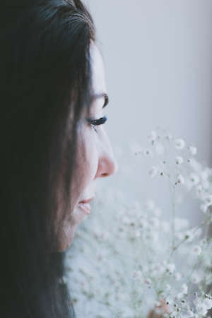 beautiful face of a brunette girl and her eyelashes close up in profileの写真素材