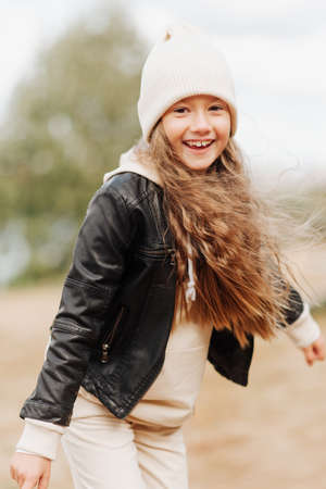 cute little girl in white hat and black leather jacket autumn photographyの写真素材