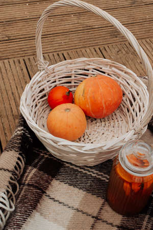 white wicker basket with pumpkins and jam autumn picnic close upの写真素材