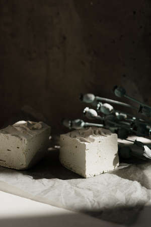interesting handmade soap in white on the background of the wall and flowers