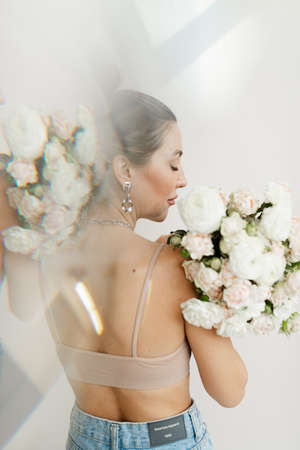 young spanish girl with naked back in bra holding a bouquet of flowers double exposureの写真素材