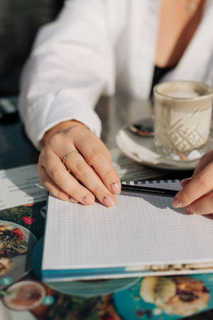 girl holding pencil and notebook white sheet of paper business photoの写真素材
