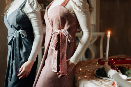 young girls in beautiful long vintage dresses on the background of a burning candleの写真素材