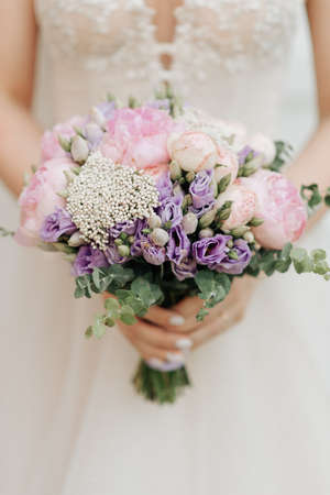 beautiful bridal bouquet holding a white wedding dressの写真素材