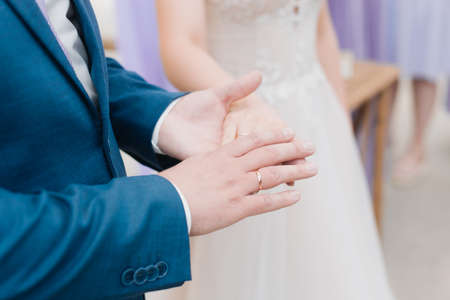 hands of bride and groom with rings close up wedding dayの写真素材