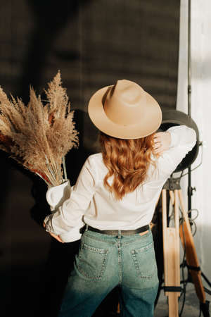 very stylish girl in white shirt hat and blue jeans posingの写真素材