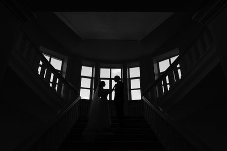 bride and groom stand on the stairs stylish black and white photo wedding