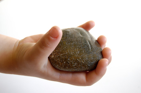 Hand of the small boy with a stoneの写真素材
