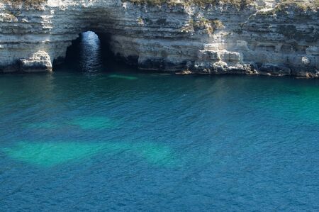 grotto in rock on blue sea の写真素材
