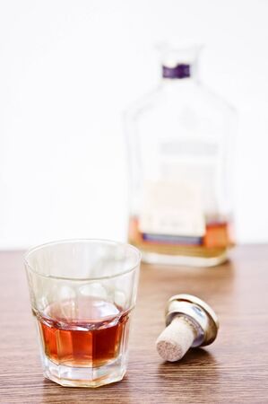 whiskey glass and bottle on wooden counter