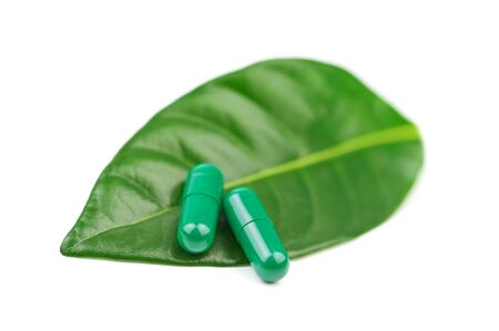 pill with leaf isolated on whiteの写真素材