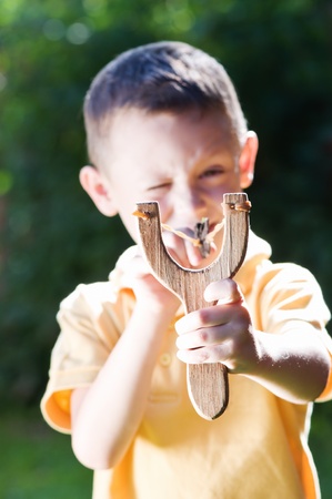 young boy with slingshot shootingの写真素材