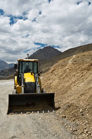 yellow bulldozer on mountain road