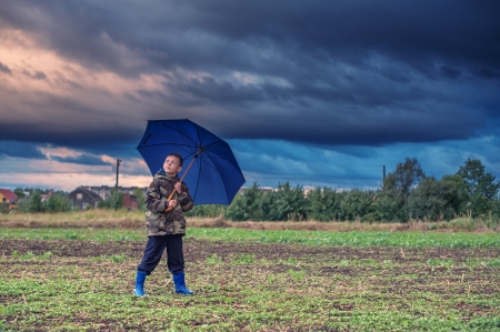 boy with umbrella before a rainの写真素材