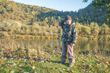 boy near lake in autumn timeの写真素材