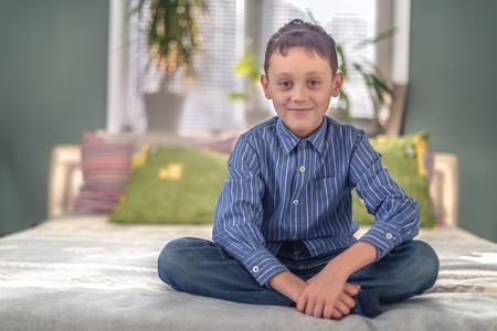 smiling child on home bedの写真素材