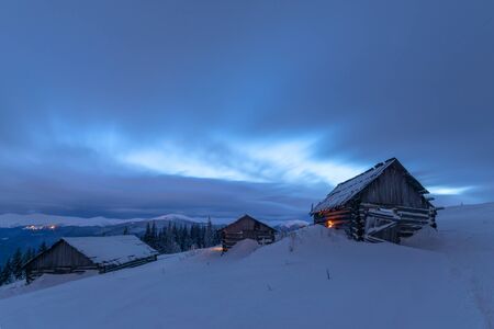 Fantastic pink evening landscape glowing by sunlight. Dramatic wintry scene with snowy house. Carpathians, Ukraine, Europe.の写真素材