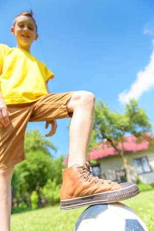 Boy with ball on green lawn. Summer time!の写真素材