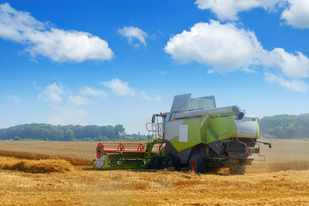 Amazing rural scene on autumn field with harvester