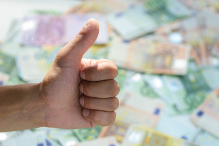 "good" gesture on cash backgroundの写真素材