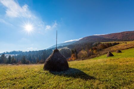 Amazing rural scene on autumn valley. Haystack on a foreground. Carpathians, Ukraine, Europe.