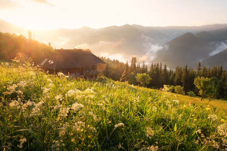 Refugio in high mountain. Orange sunrice glowing by sunlight. Summer time in highland. Alone house in the wonderlandの写真素材