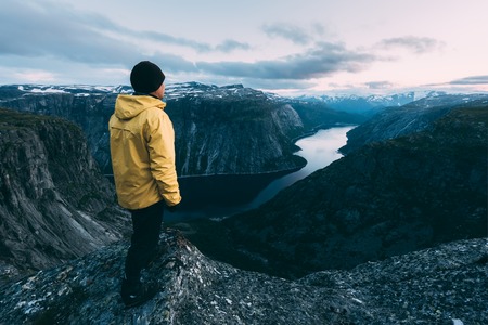 Alone tourist on Trolltunga rock - most spectacular and famous scenic cliff in Norwayの写真素材