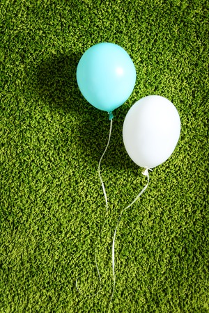 Blue and white air balloons on green carpet closeupの写真素材