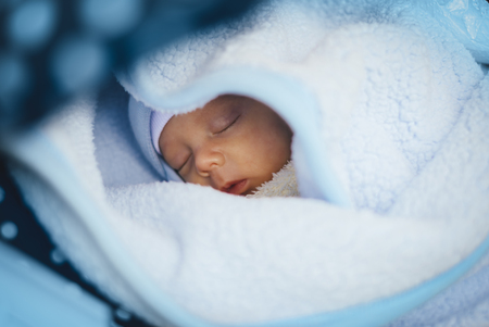 Newborn baby boy sliping in stroller. Closeup portraitの写真素材