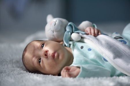 Newborn baby boy portrait on white carpet closeup. Motherhood and new life conceptの写真素材
